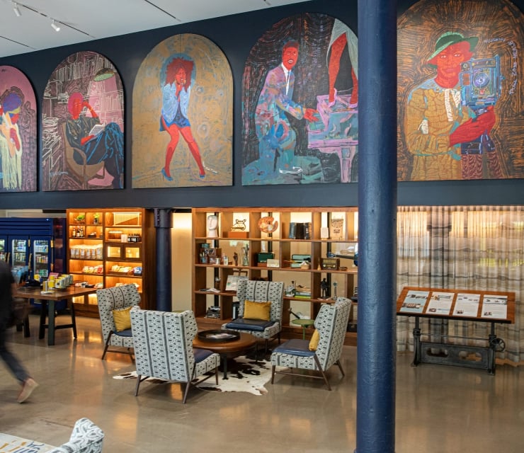 The lobby of The Untitled Nashville Hotel with beautiful art covering the walls and plenty of spots to relax and take a seat