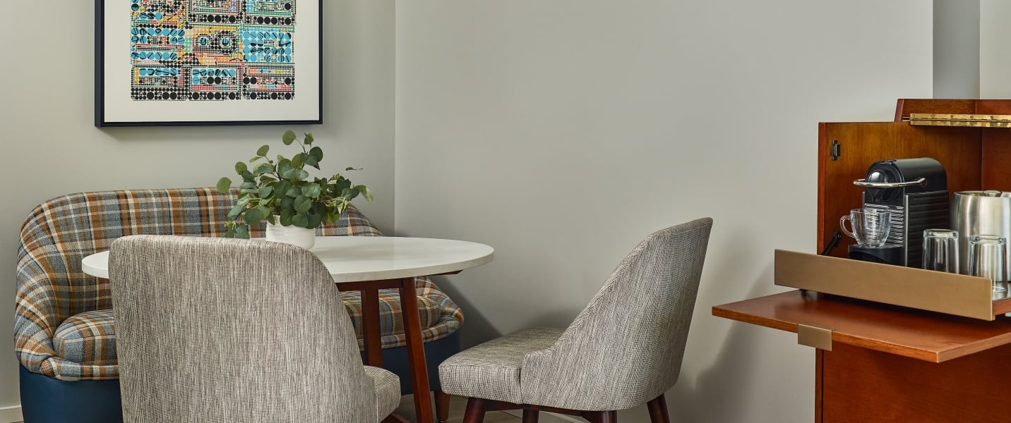 Seating alcove and dining area inside the Deluxe King 1 Bedroom Suite at The Untitled Nashville Hotel.