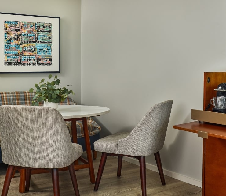 Seating alcove and dining area inside the Deluxe King 1 Bedroom Suite at The Untitled Nashville Hotel.