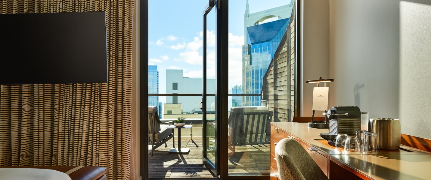 The view looking out on a terrace of an Untitled Nashville suite, with the Nashville skyline in the background