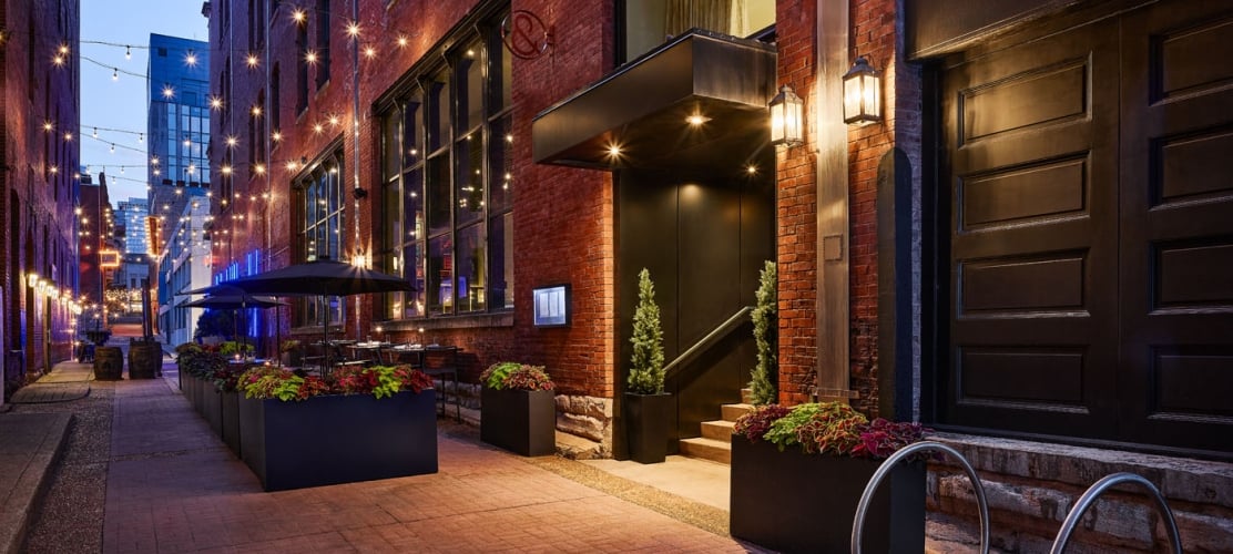 Bankers Alley entrance of The Untitled Nashville Hotel illuminated at dusk.