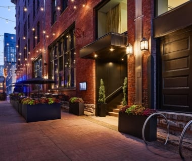 Bankers Alley entrance of The Untitled Nashville Hotel illuminated at dusk.